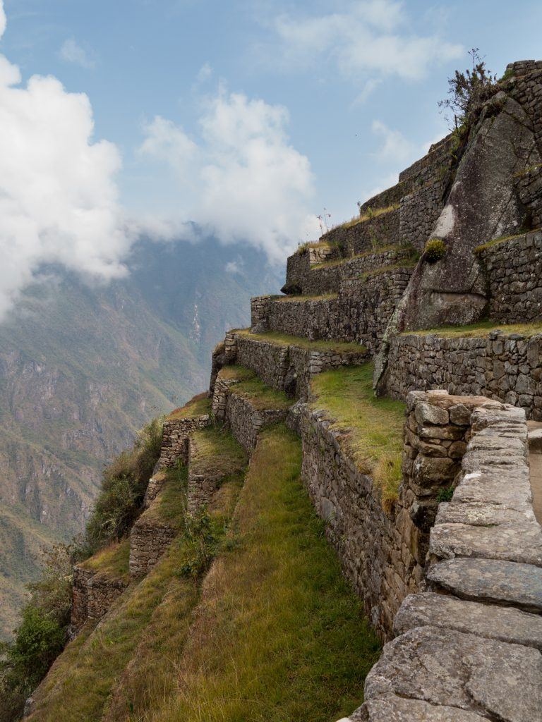 Morning views of Machu Picchu as mist clears from the mountainside with terraces