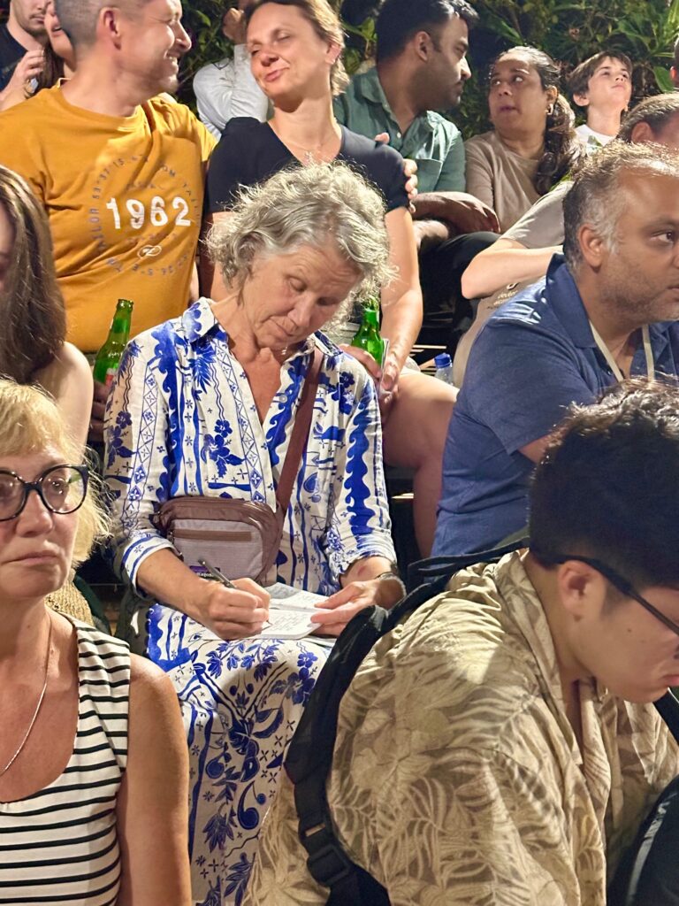 Immersed in writing in the stands of the Kecak Dance. Photo by Laura Davis.